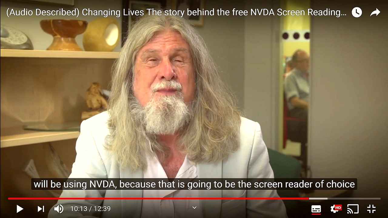 Screenshot from "Changing Lives: The story behind the free NVDA screen reader".  Kevin Carey (Chair RNIB), subtitle text "will be using NVDA because that is going to be the screen reader of choice".