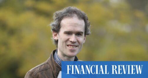 Photograph of Michael Curran in front of blurred green background with "FINANCIAL REVIEW" in white on blue lower right - Image from Australian Financial Review article