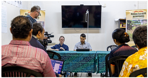 Photo of Mick & Jamie speaking to a room of people from the Samoa Blind Person's Association.