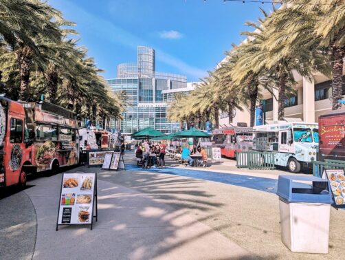 Several rows of food trucks with tables between.