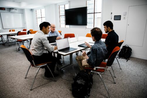 Ki from Dot Inc, with James Boreham, Mick and Jamie as Mick articulates a point about the Dot Pad on the table in front of him.