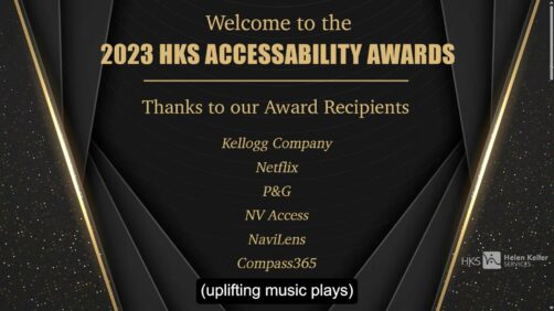 A decorative dark brown and gold background with text: " Welcome to the 2023 HKS ACCESSABILITY AWARDS --- Thanks to our Award Recipients Kellogg Company Netflix P&G NV Access NaviLens Compass365 " At the bottom is the first line of captions which reads "(uplifting music plays)". Now you'll need to watch the awards to hear what the uplifting music is!