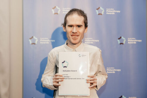 Michael Curran holding the finalist certificate for the Inclusion award at the Philanthropy Australia Awards 2024.